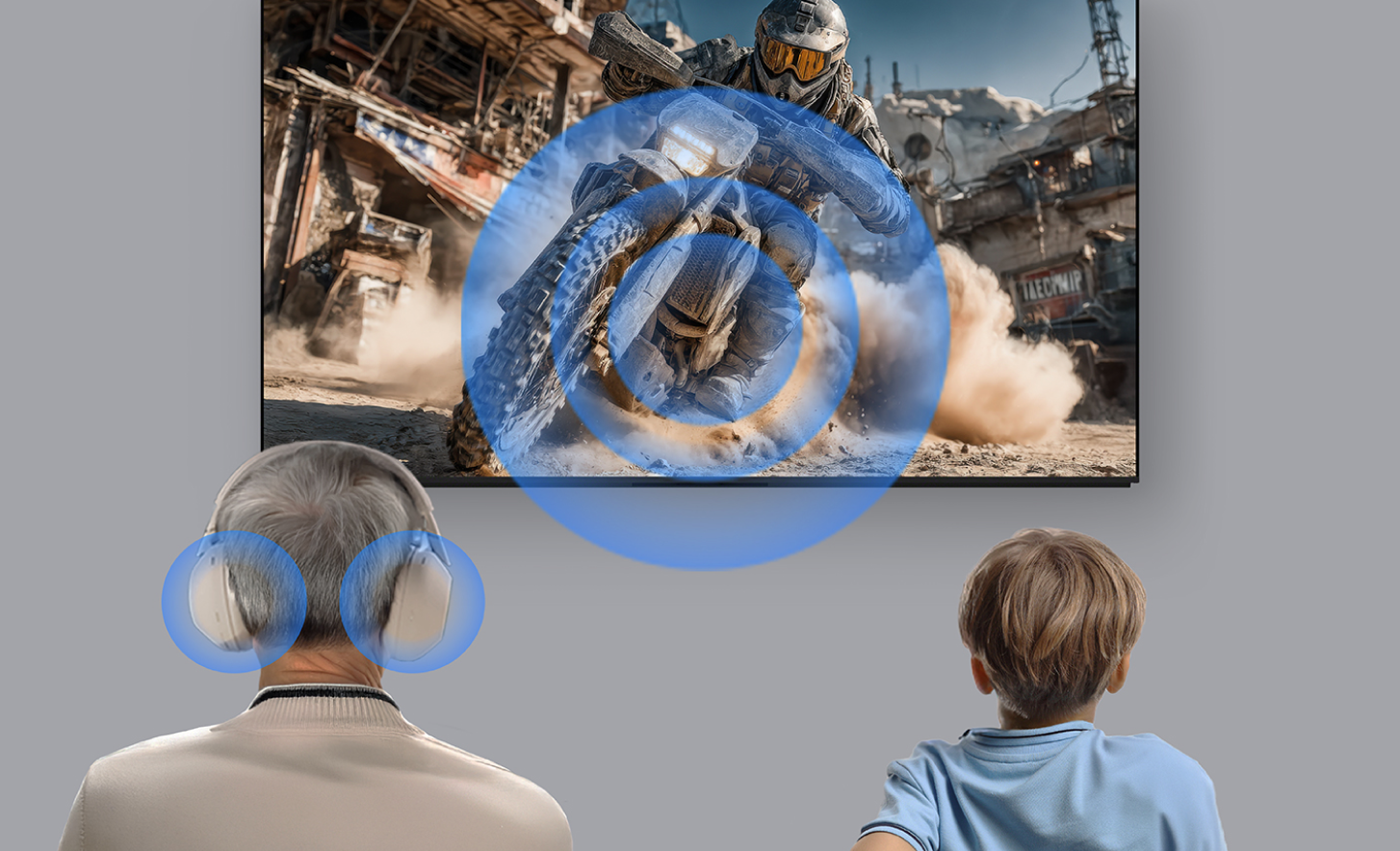 Seseorang berusia paruh baya mengenakan headphone di samping anak kecil yang sedang menonton adegan aksi di layar TV. Gelombang suara biru memancar dari layar ke arah pendengar, menggambarkan pemutaran audio simultan sehingga kedua penonton mendengar suara konten yang sama.